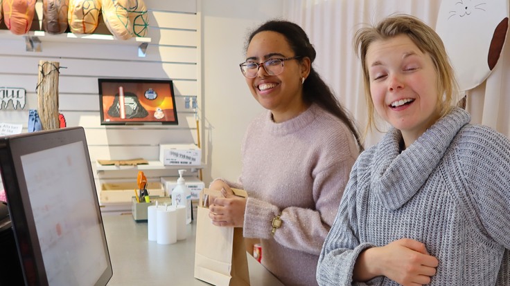 Två tjejer står innanför en kassadisk